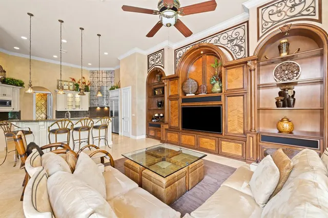 a living room with furniture a flat screen tv and a floor to ceiling window