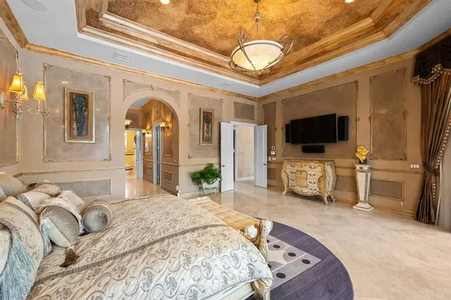 a spacious bedroom with a bed and a flat tv screen