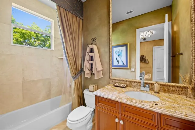 a bathroom with a granite countertop sink toilet and shower
