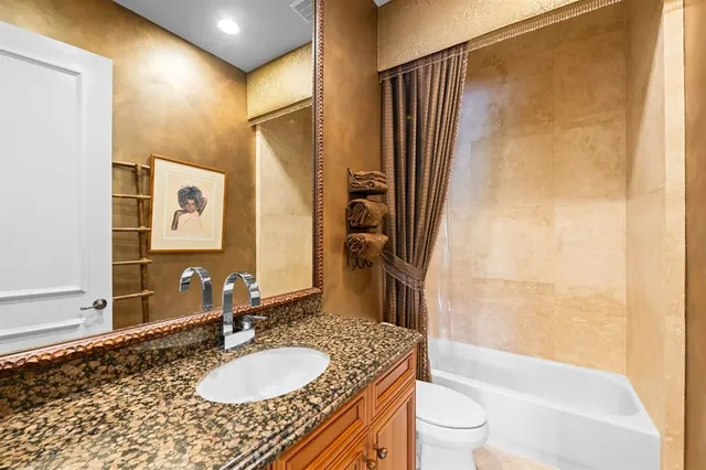 a bathroom with a granite countertop sink toilet and shower