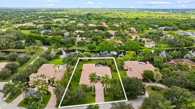 an aerial view of residential houses with outdoor space and trees