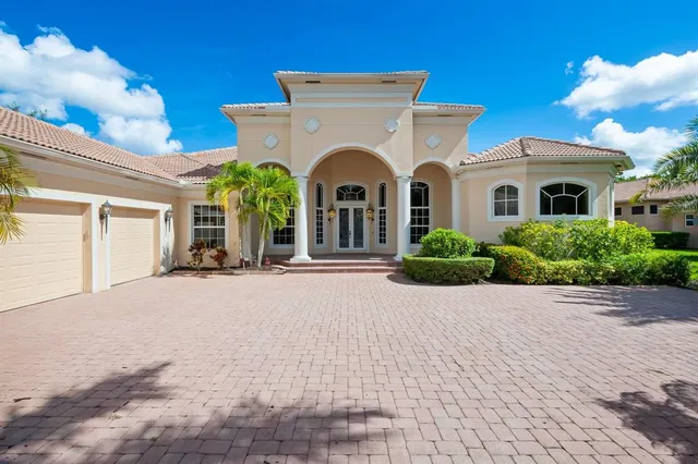 a front view of a house with yard and parking