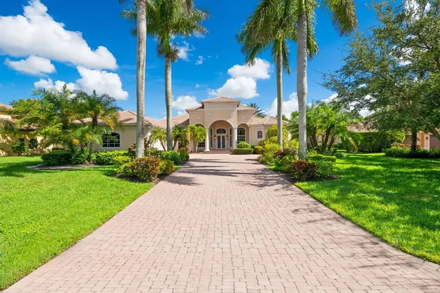 a front view of a house with garden and trees