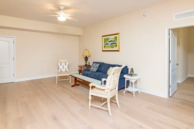 a dining room with wooden floor and a chandelier fan