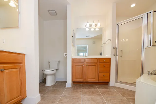 a spacious bathroom with a granite countertop sink a mirror and a toilet