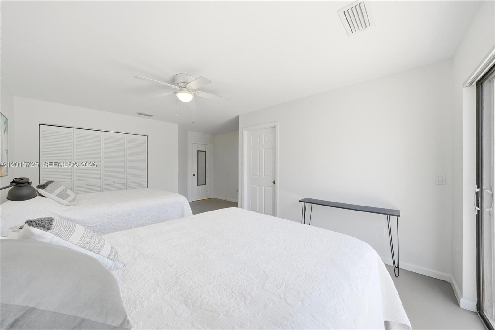 11008 Boca Woods Lane Boca Raton, FL 33428 - Photo 26 of 70 a bedroom with a large bed and a ceiling fan