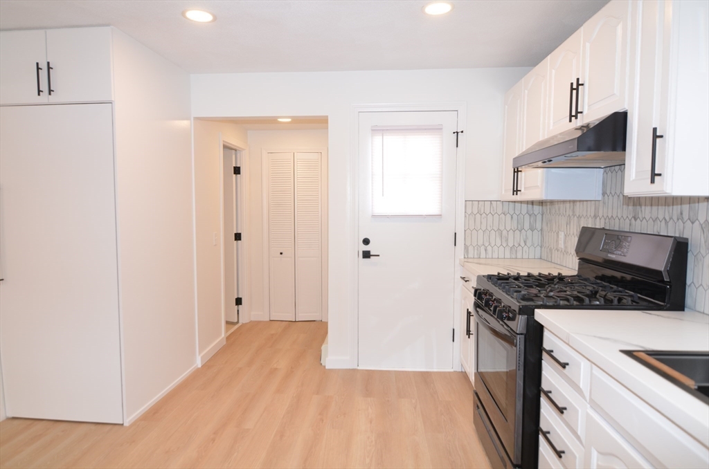 88 Cleveland Avenue, Unit 2 Everett, MA 02149 - Photo 3 of 23 a kitchen with a stove and a white cabinet