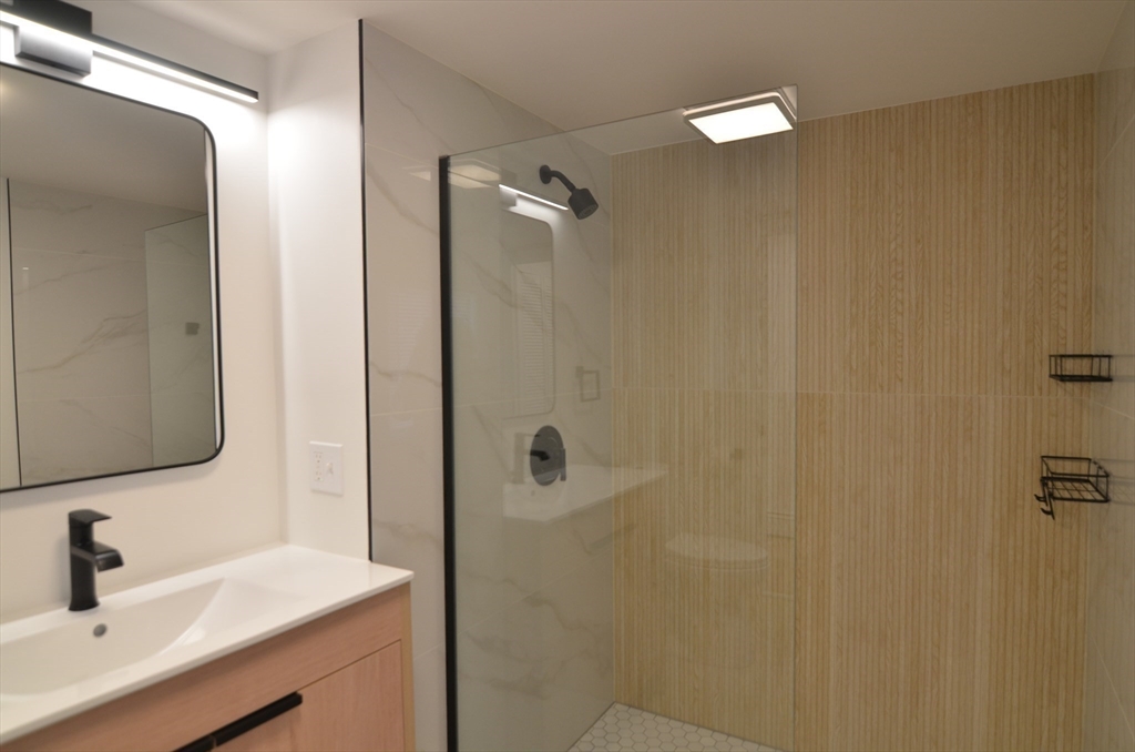 88 Cleveland Avenue, Unit 2 Everett, MA 02149 - Photo 5 of 23 a bathroom with a sink a mirror and shower