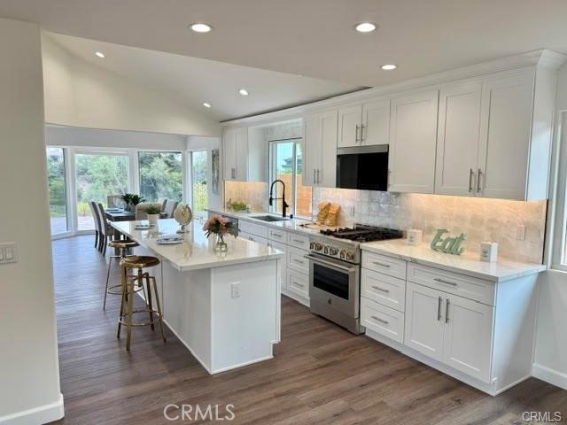 406 Calle Vista Torito San Clemente, CA 92672 - Photo 15 of 29 a open kitchen with stainless steel appliances granite countertop a stove top oven a sink dishwasher a dining table and chairs with wooden floor