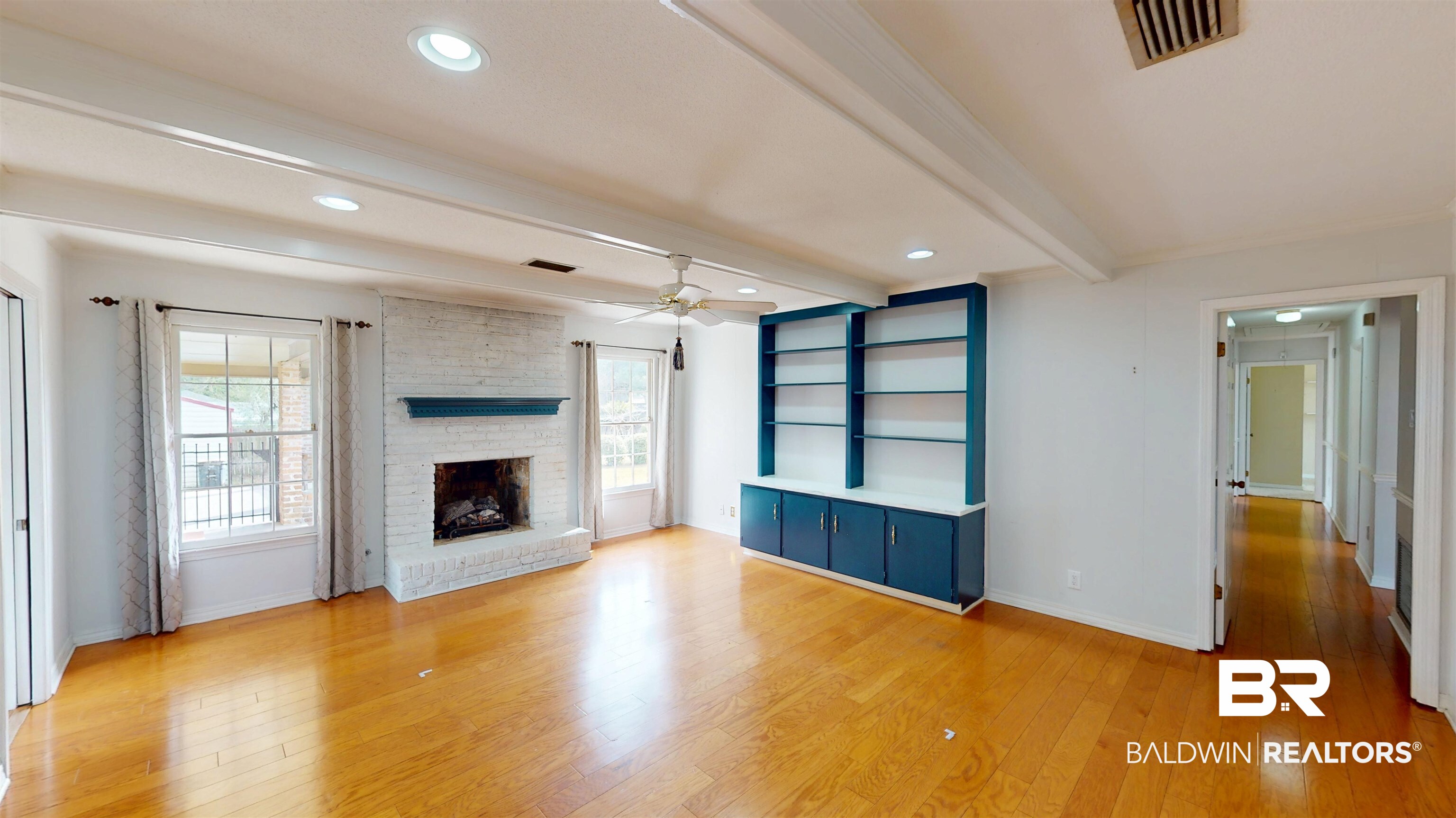 609 Burlington Court Mobile, AL 36608 - Photo 9 of 19 Unfurnished living room featuring beam ceiling, light wood-style floors, a ceiling fan, a brick fireplace, and recessed lighting