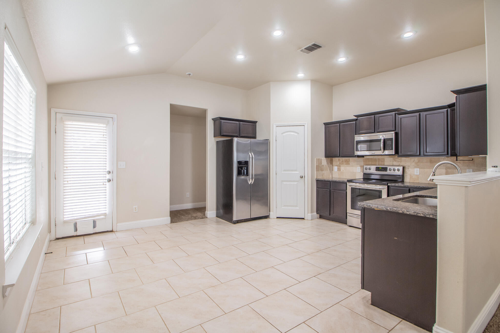 7409 101st Street Lubbock, TX 79424 - Photo 6 of 22 a kitchen with stainless steel appliances granite countertop a refrigerator and a stove top oven