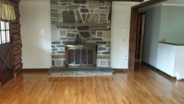 1 Breakneck Road Sturbridge, MA 01566 - Photo 13 of 30 an empty room with wooden floor and a fireplace