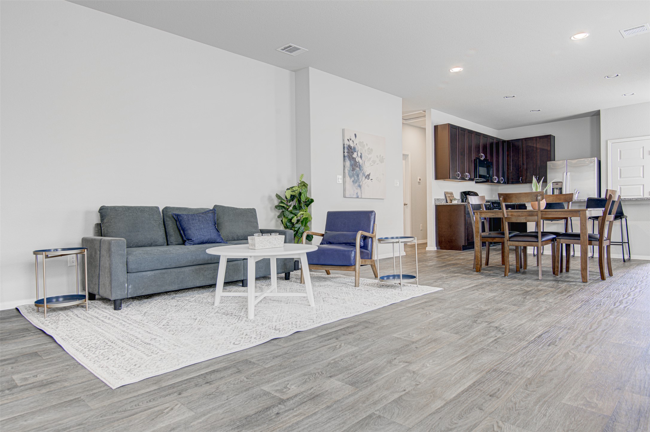 156 Tillage Road Elgin, TX 78621 - Photo 25 of 25 An open floorplan seamlessly connects the living and dining spaces to a modern kitchen.
