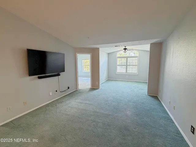 a view of a livingroom with an empty space and a window