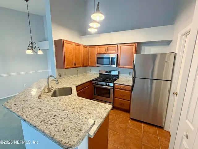 a kitchen with stainless steel appliances granite countertop a refrigerator stove microwave and sink