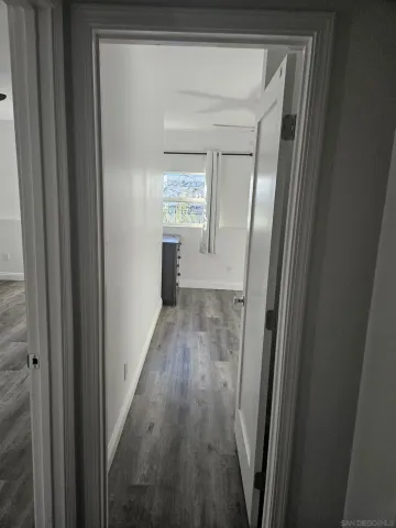 a view of a hallway with wooden floor and stairs