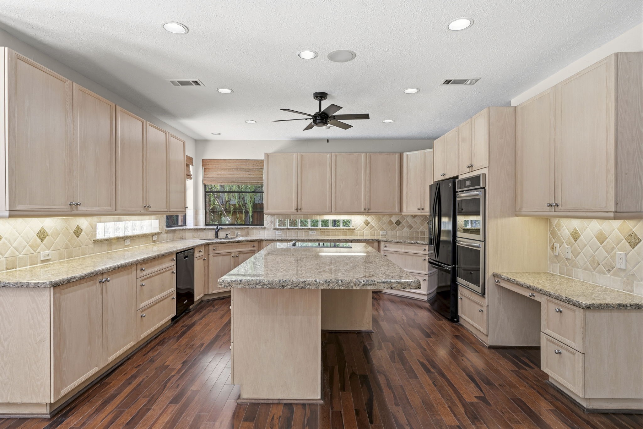 18503 Cabaniss Circle Spring, TX 77379 - Photo 17 of 49 The heart of the home is this spacious island kitchen, featuring abundant cabinetry, granite countertops, a large center island with cooktop, double ovens, and generous workspace.