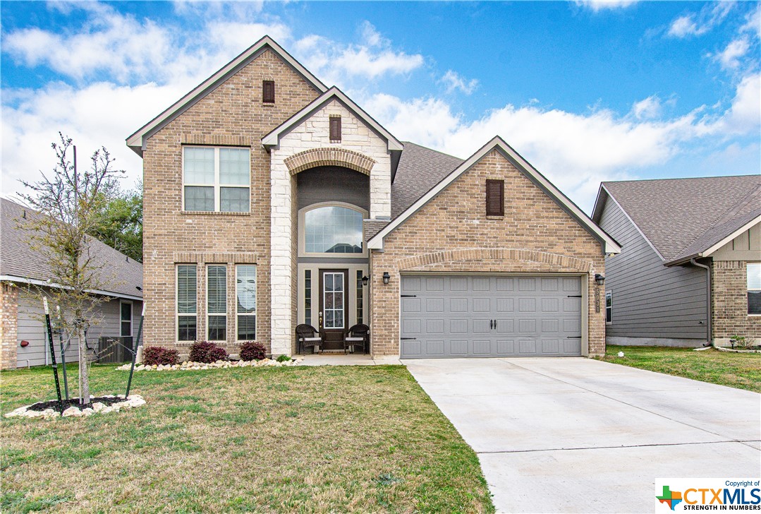 a front view of a house with a garden and plants