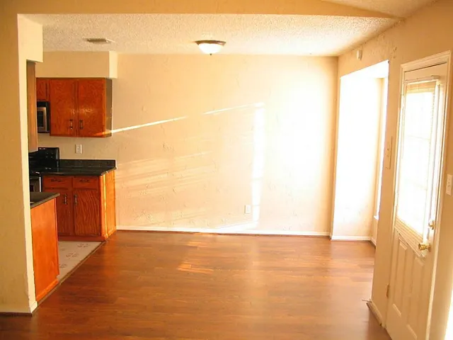 a view of a room with wooden floor and a window