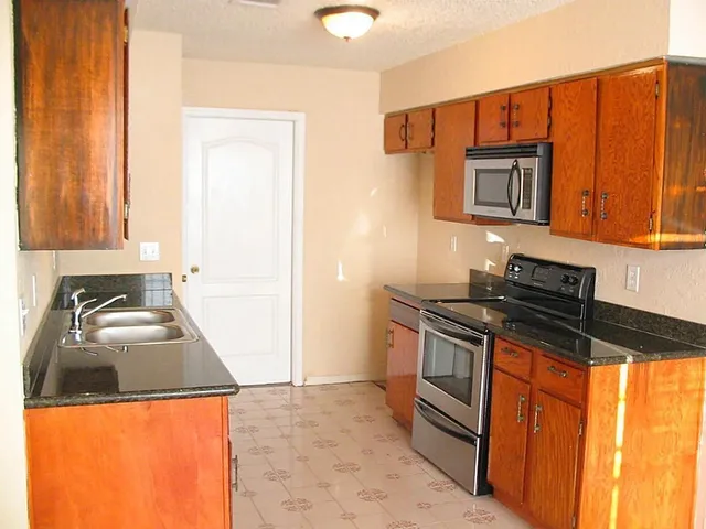 a kitchen with stainless steel appliances granite countertop a stove and a sink