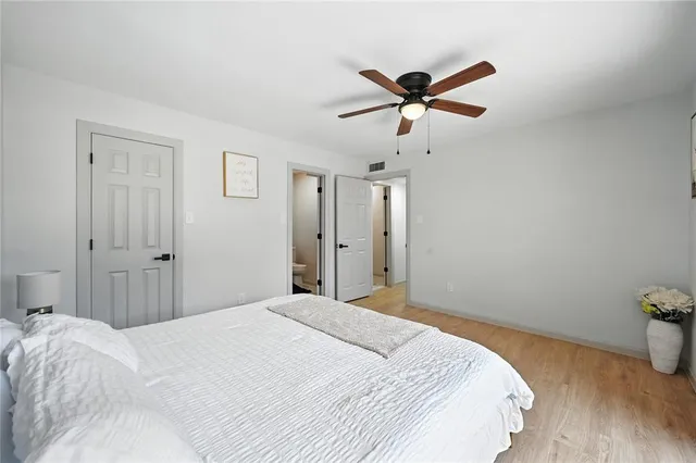 a bedroom with a bed and a ceiling fan