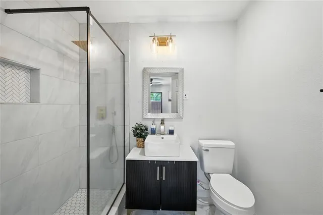 a bathroom with a sink vanity mirror and toilet