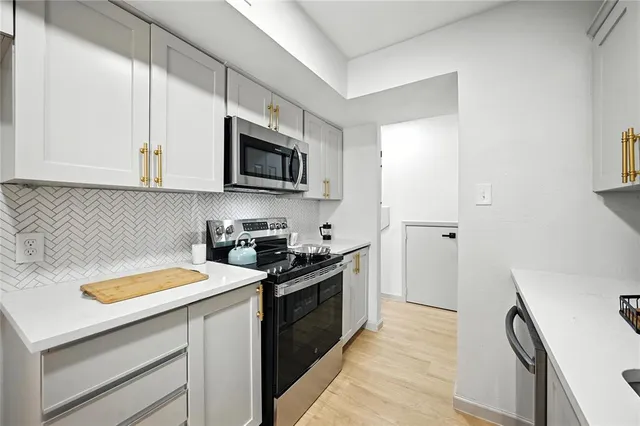a kitchen with a sink a stove and cabinets