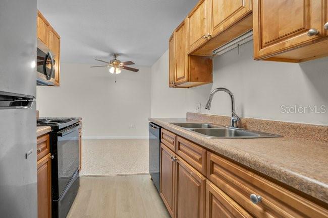 1695 Lee Road, Unit E204 Winter Park, FL 32789 - Photo 13 of 27 a kitchen with a sink and a stove top oven