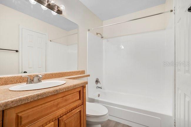1695 Lee Road, Unit E204 Winter Park, FL 32789 - Photo 18 of 27 a bathroom with a granite countertop sink toilet and shower