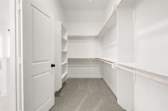 a view of walk in closet with empty racks