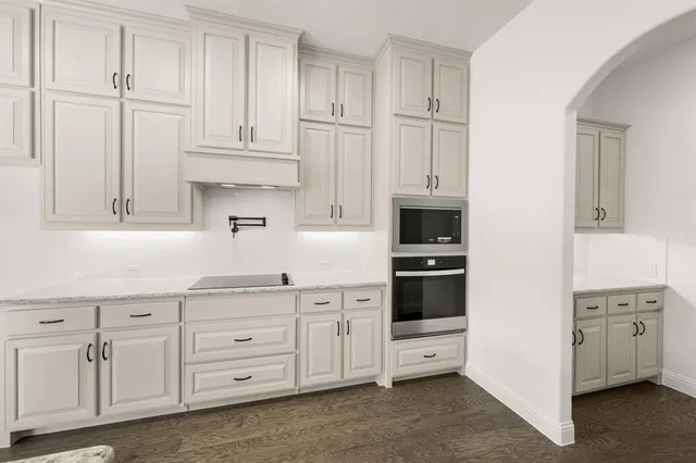 a kitchen with white cabinets and white appliances