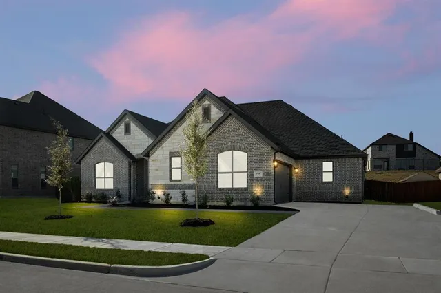 a front view of a house with a garden and plants
