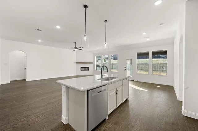a kitchen with a sink stove and wooden floor