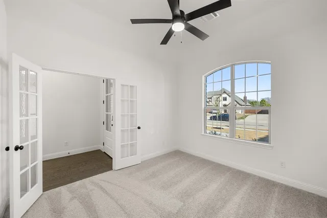 an empty room with windows and fan