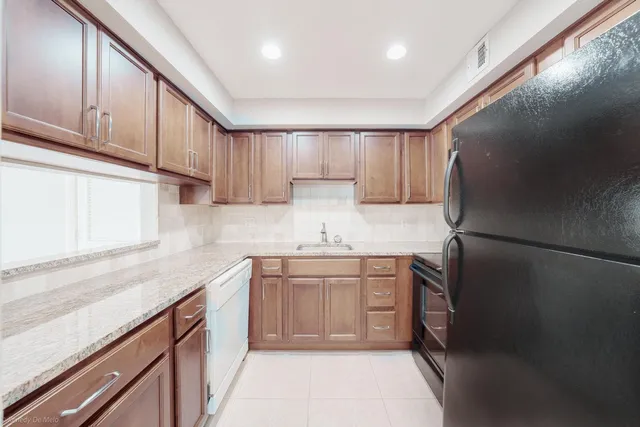 a kitchen with granite countertop cabinets stainless steel appliances and a counter space