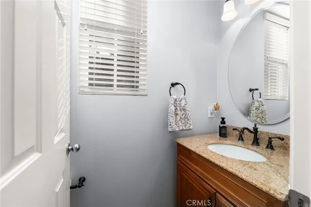 a bathroom with a granite countertop sink and a mirror
