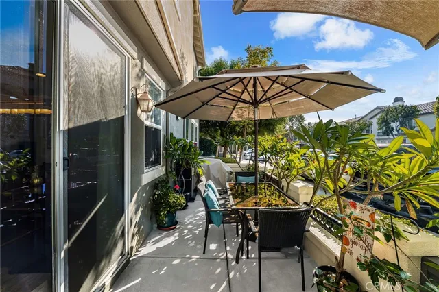 a view of a patio with table and chairs under an umbrella