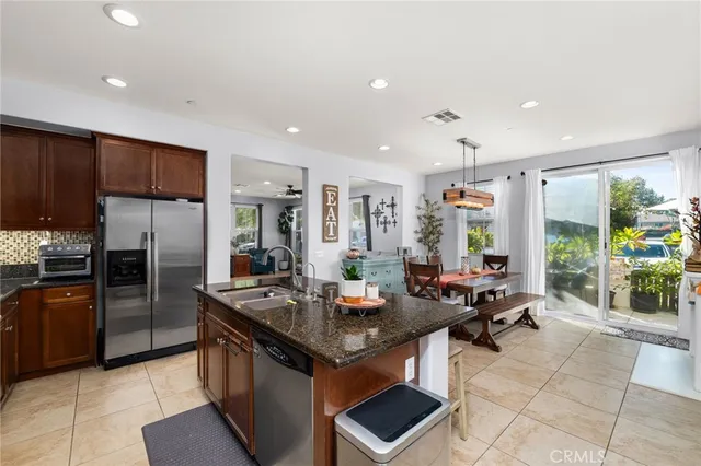 a kitchen with granite countertop kitchen island stainless steel appliances a sink stove and refrigerator