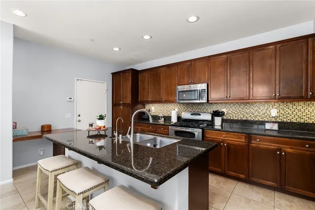 a kitchen with a sink a microwave a stove and cabinets