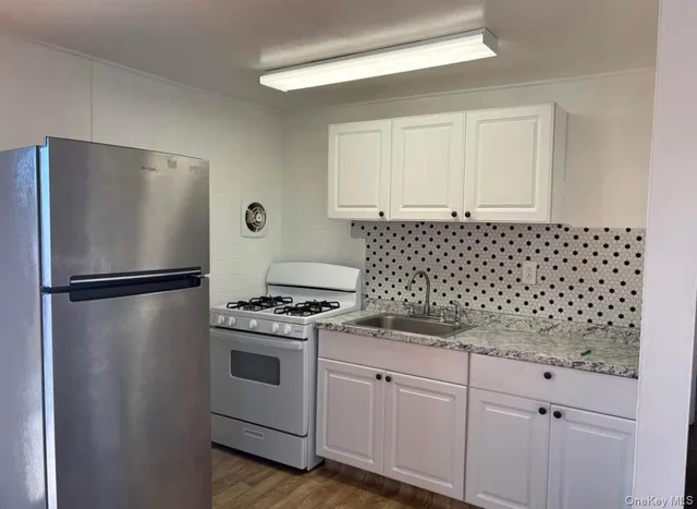 a kitchen with a refrigerator stove and white cabinets