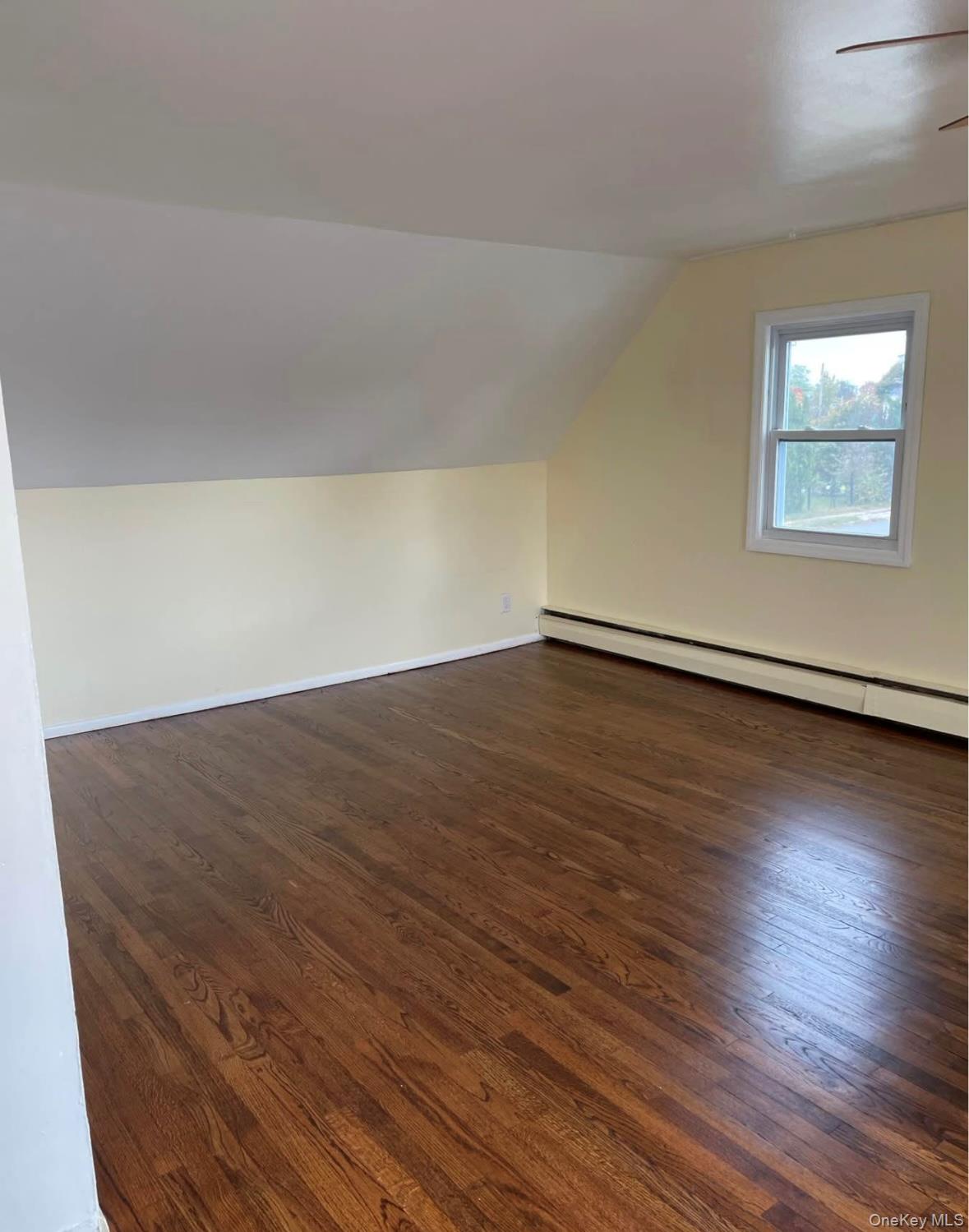 32 Winding Road Hicksville, NY 11801 - Photo 7 of 12 an empty room with wooden floor and windows