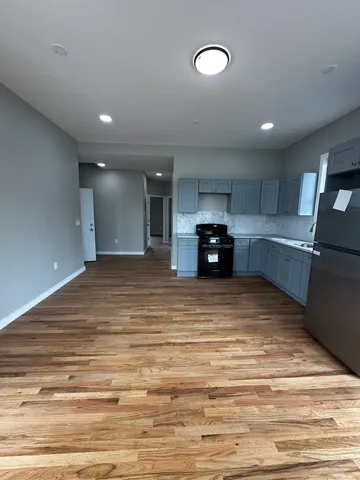 a large kitchen with stainless steel appliances granite countertop a refrigerator and a stove