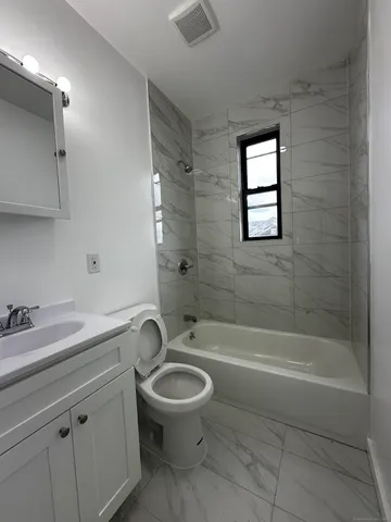 a bathroom with a granite countertop toilet a sink and bathtub