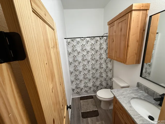 a bathroom with a granite countertop sink toilet and shower curtain