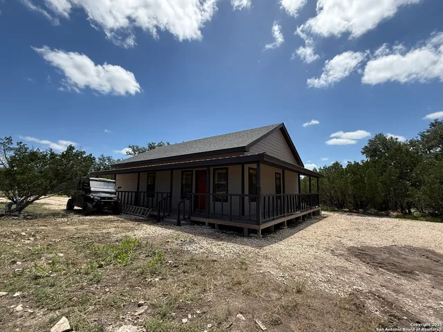a view of a small yard with wooden fence and a barbeque