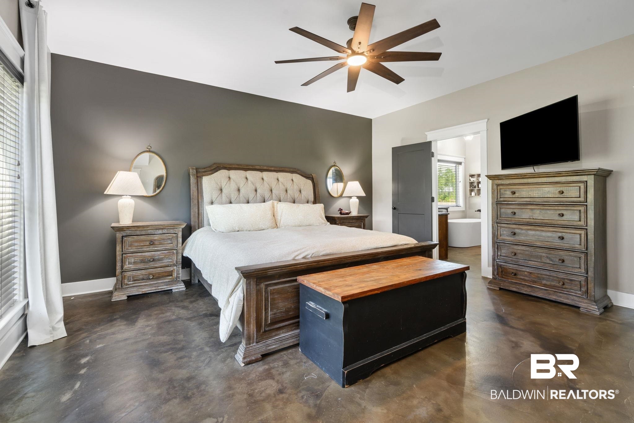 11025 Creax Road Axis, AL 36505 - Photo 23 of 45 Spacious room featuring polished concrete flooring, a tufted upholstered headboard, and an eight-blade ceiling fan with integrated lighting