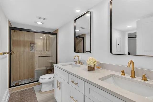 a bathroom with a sink a toilet and shower