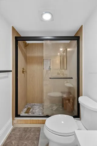 a bathroom with a granite countertop toilet a sink and shower