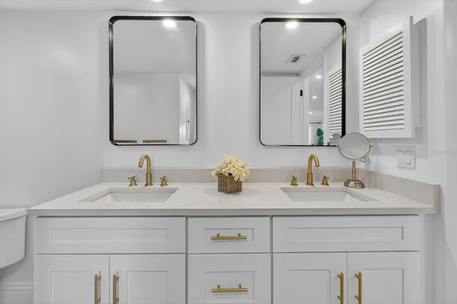 a bathroom with double vanity sinks and two mirror
