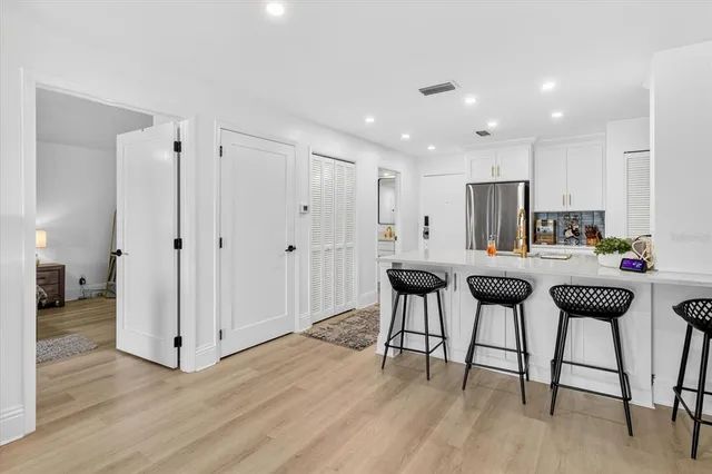 a kitchen with stainless steel appliances kitchen island granite countertop wooden floors and white counter top